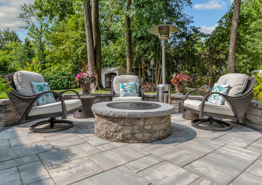 Three chairs and a firepit in an outdoor patio.